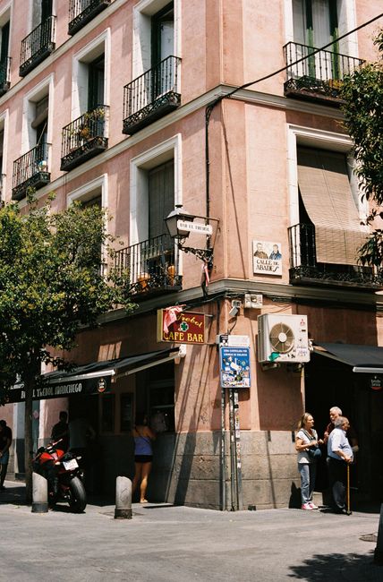 A picturesque corner café in Madrid with classic European architecture under a clear sky.