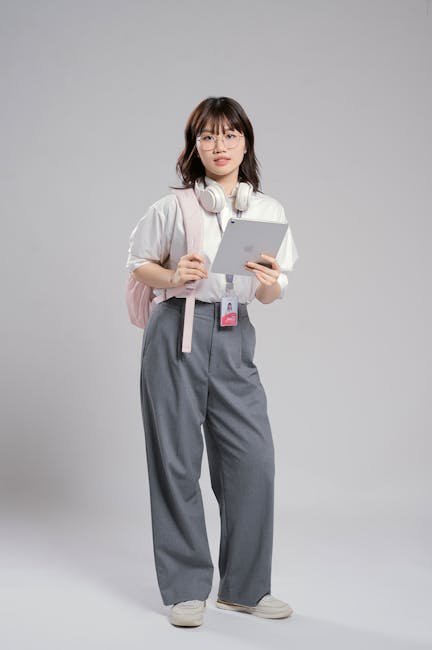 Confident young woman with headphones holding a tablet, ready for study or work.