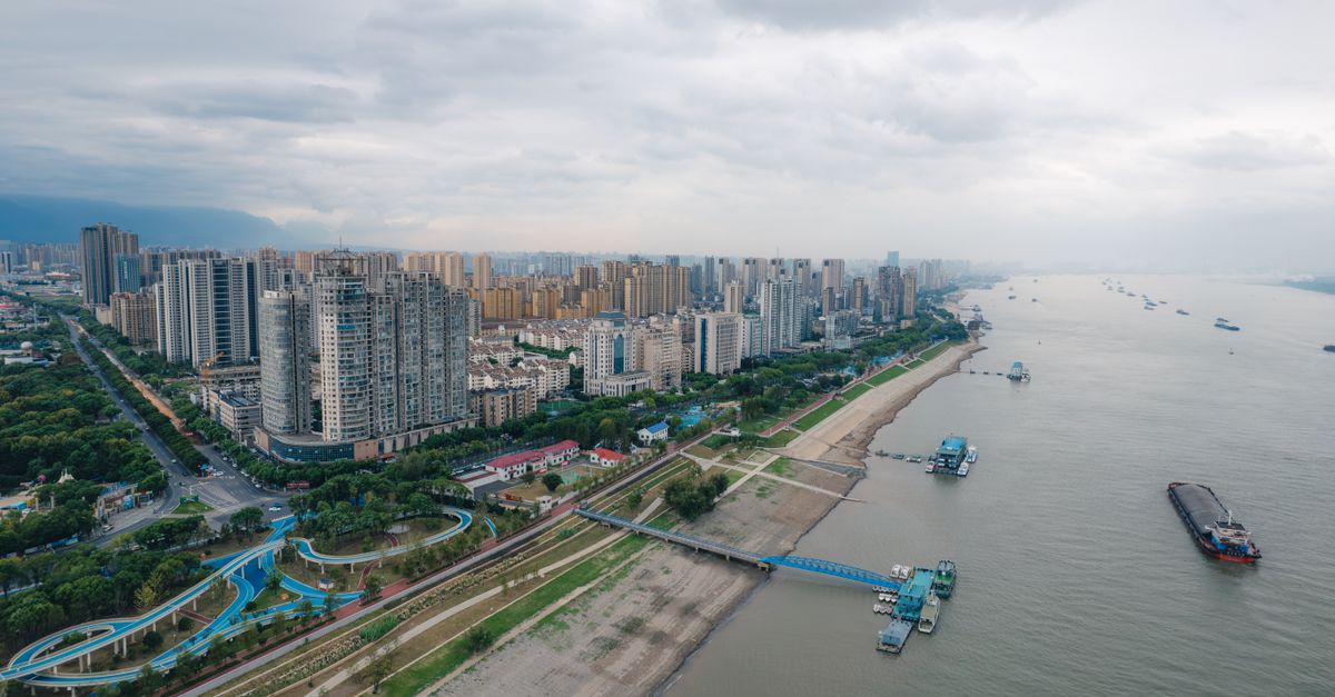 Panoramic aerial view of a cityscape next to a river in China.