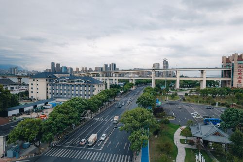 Free Aerial view of a cityscape with a highway, modern buildings, and greenery. Stock Photo