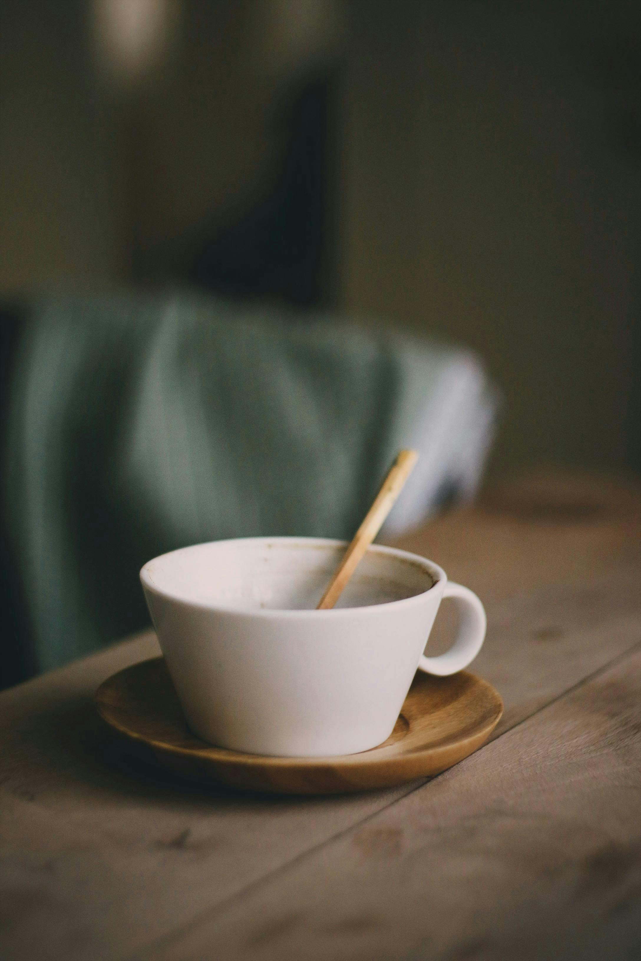 Warm ceramic coffee cup on a wooden table in a cozy setting.