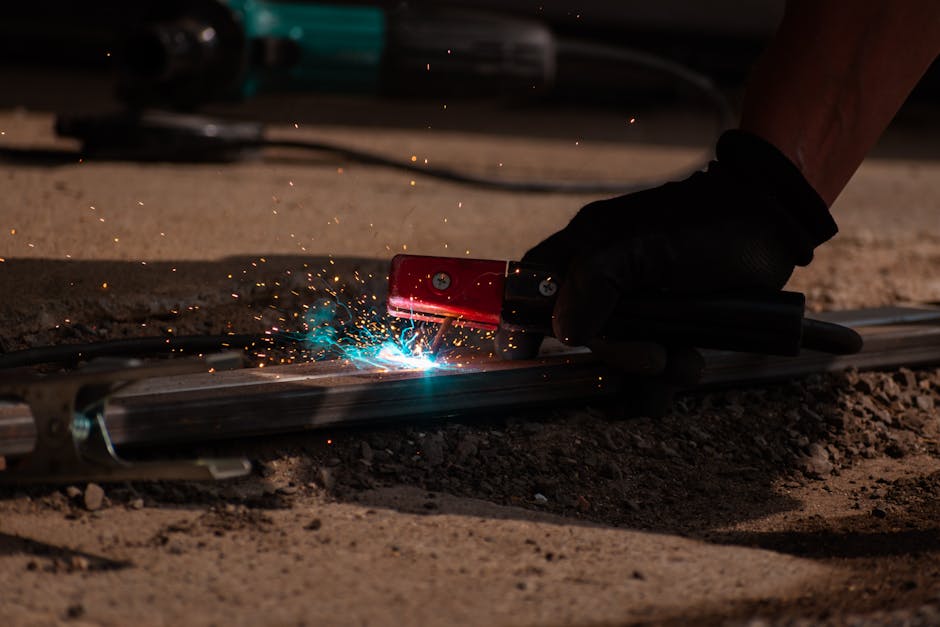 Detailed close-up of welding process with tool, sparks, and glowing metal.