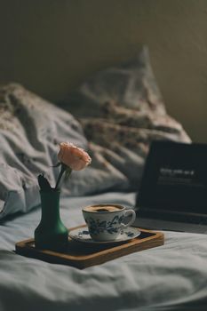 Sunlit minimalist interior of guest suite bedside table with warm coffee