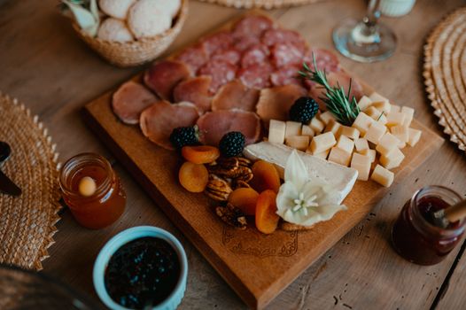 Elegant cheese and charcuterie board featuring assorted cheeses, meats, and fruits, perfect for gourmet gatherings.