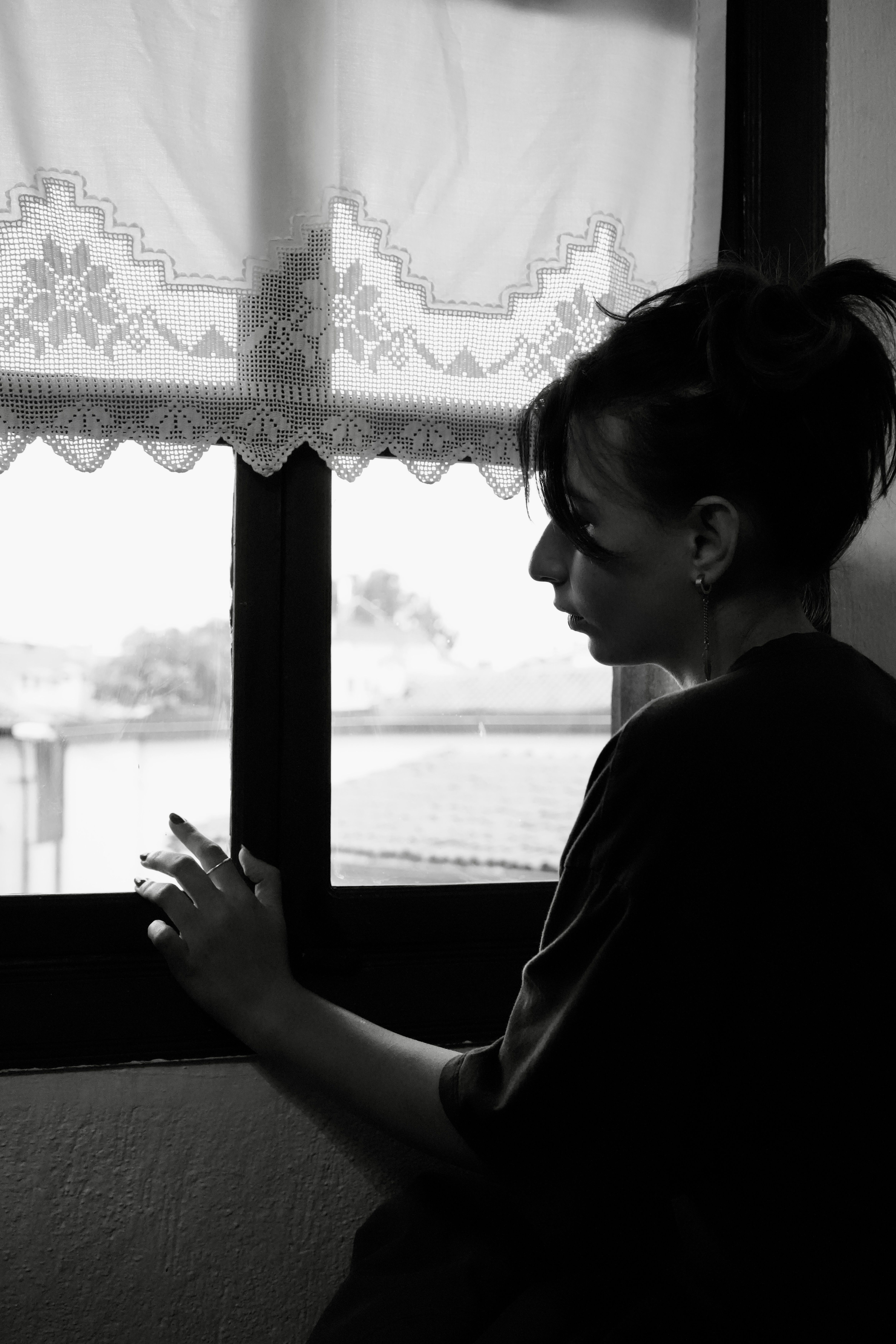 Woman Contemplating by Window in Black and White · Free Stock Photo