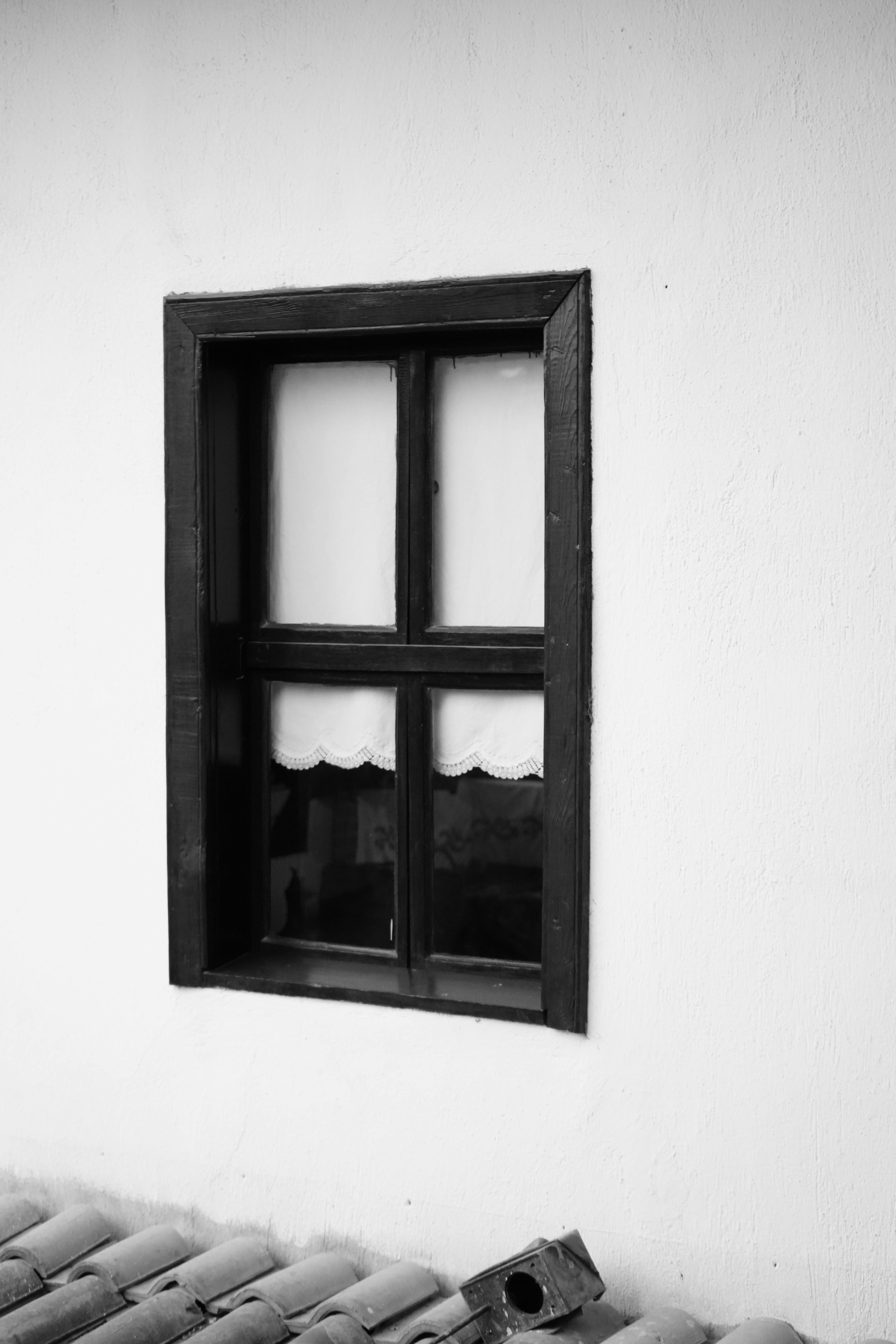 Classic wooden frame window on white wall, vintage style.