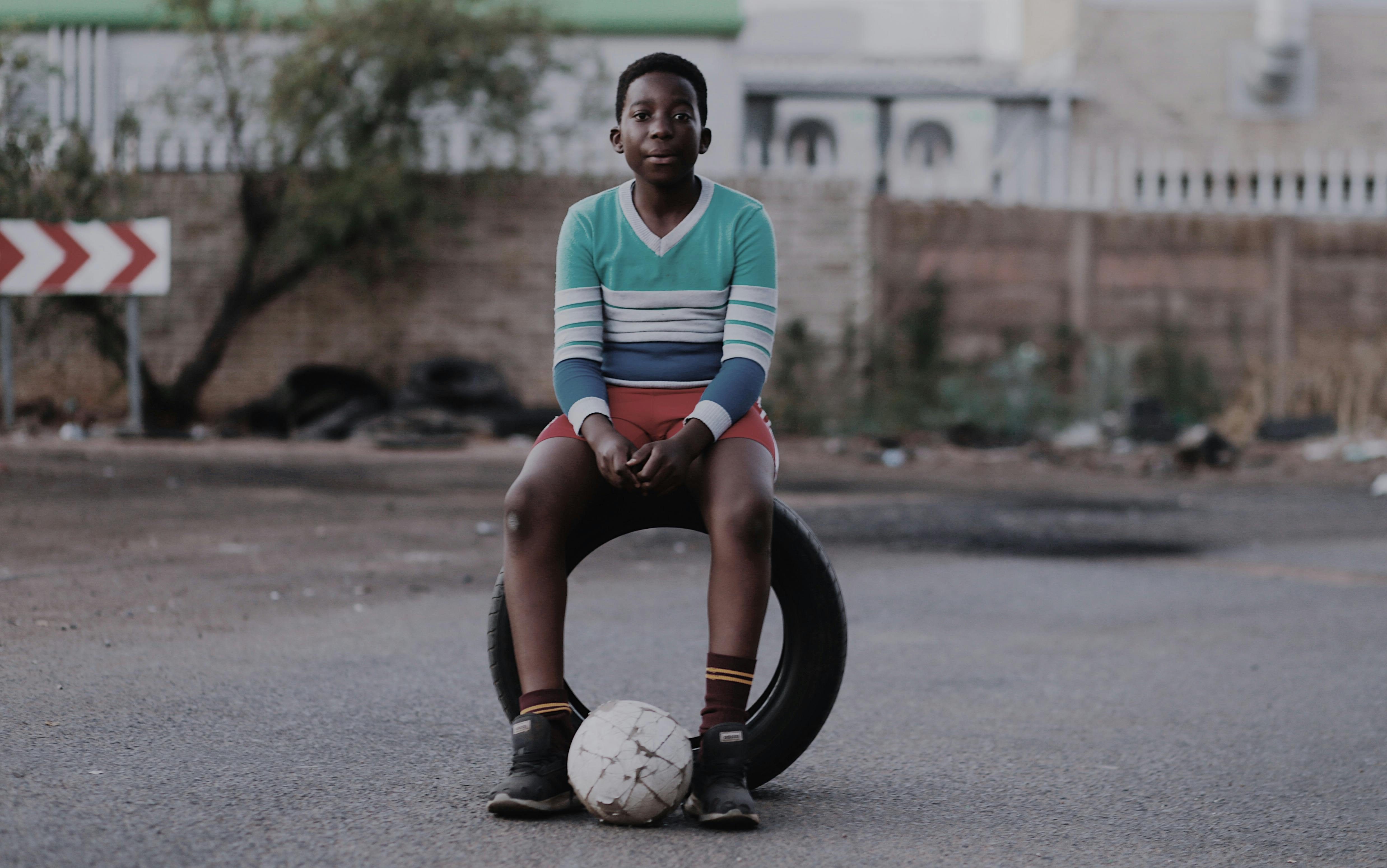 boy sitting on vehicle tire