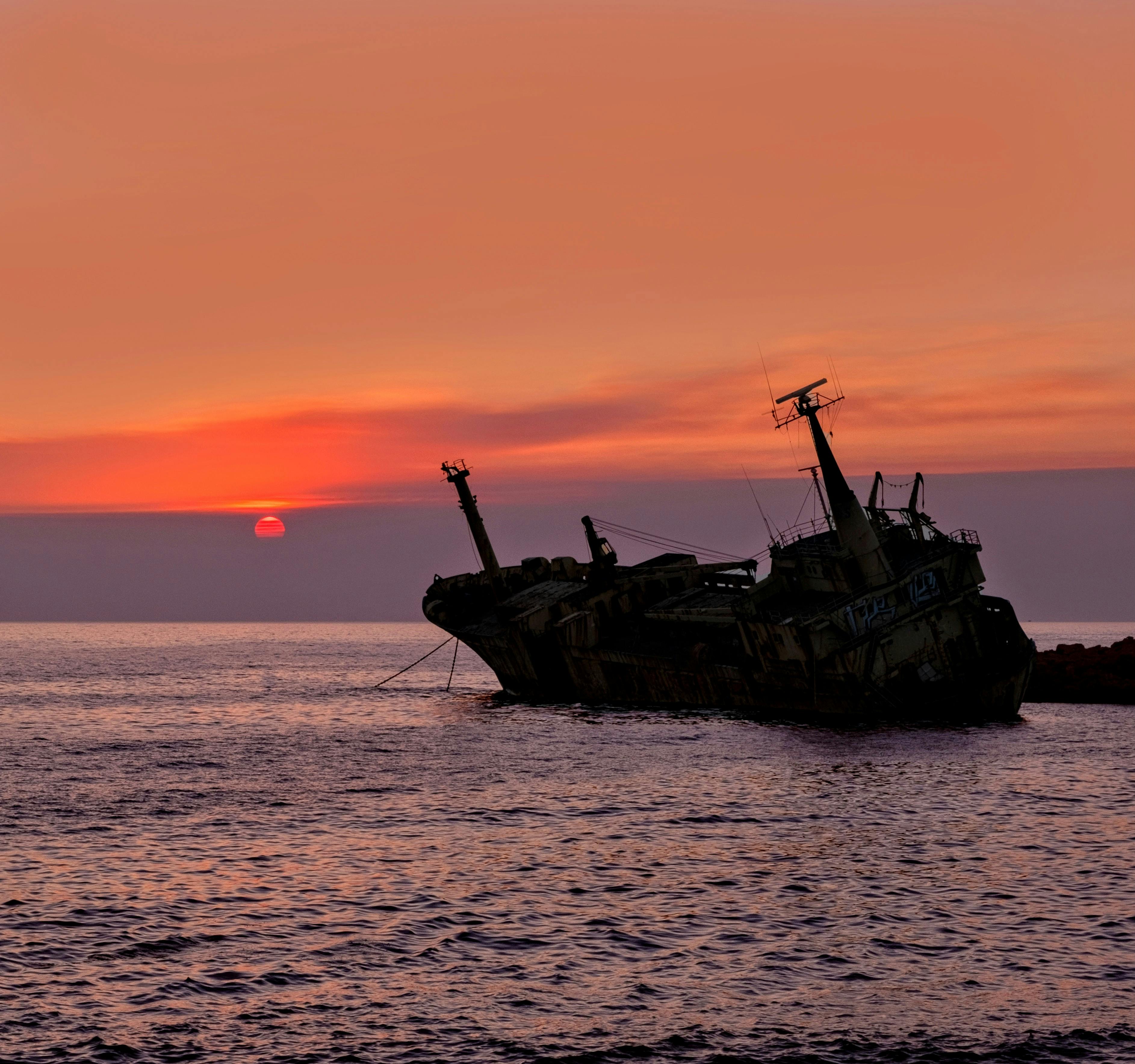A dramatic shipwreck silhouetted by a vibrant sunset over the Paphos coastline, Cyprus. - Photo by Rob Mowe on Pexels