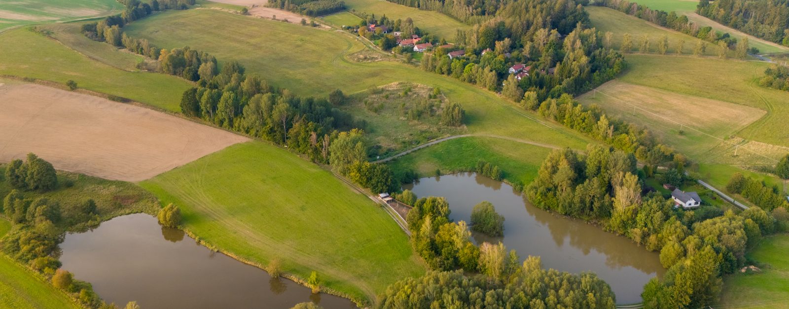 Scenic aerial landscape of the Czech countryside with lush greenery and lakes.