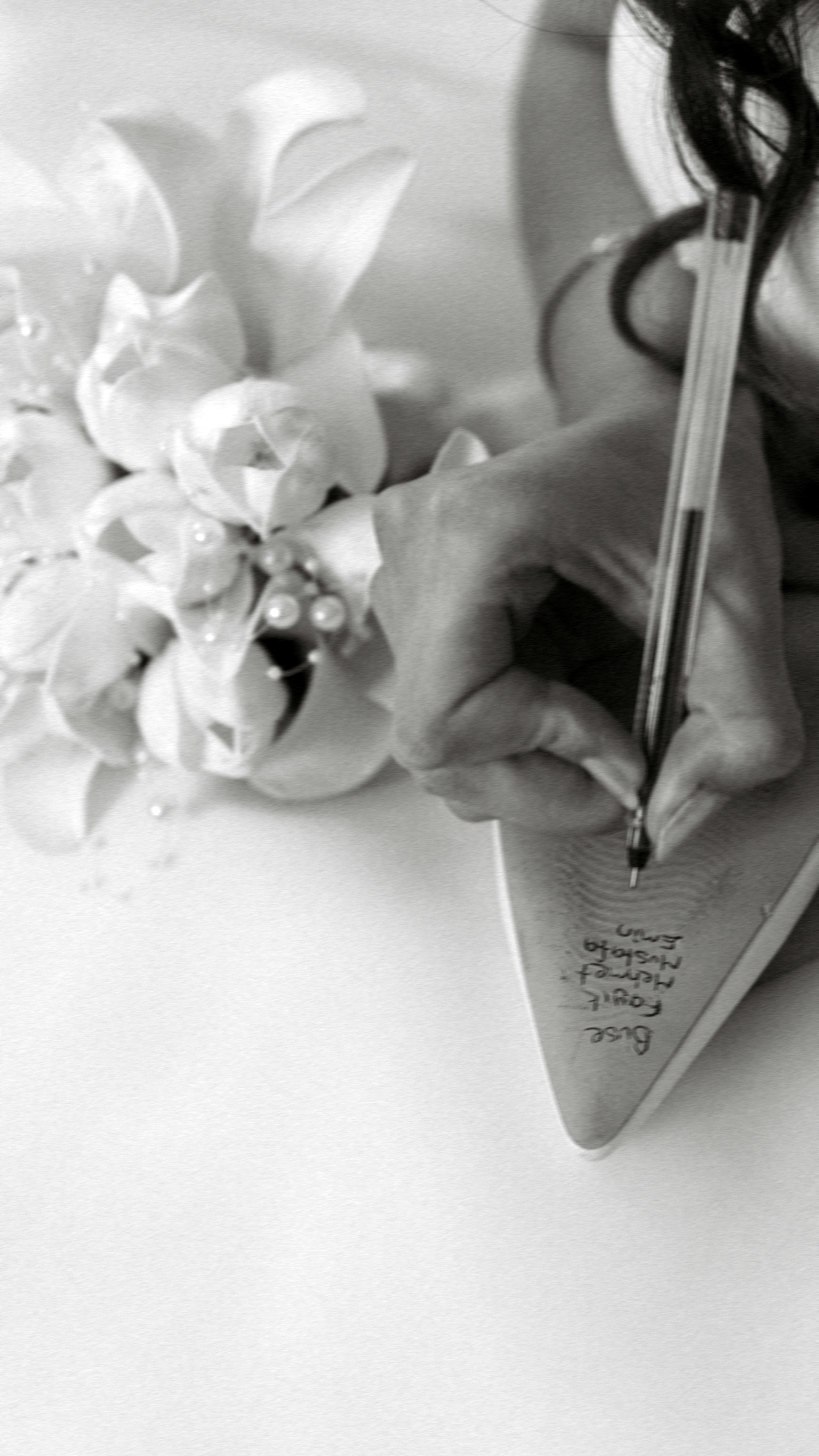 無料 花嫁がブーケと一緒にウェディングシューズに名前を書く 写真素材