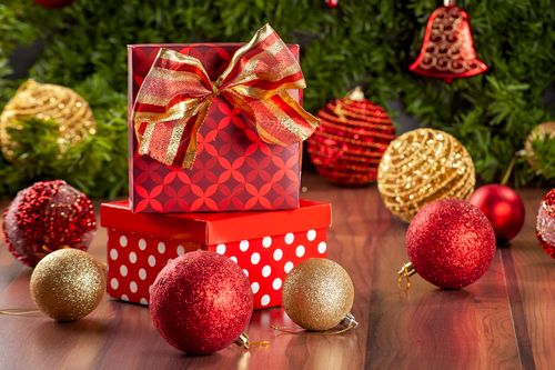 Free Colorful Christmas gift boxes with ornaments and festive decorations on a wooden surface. Stock Photo