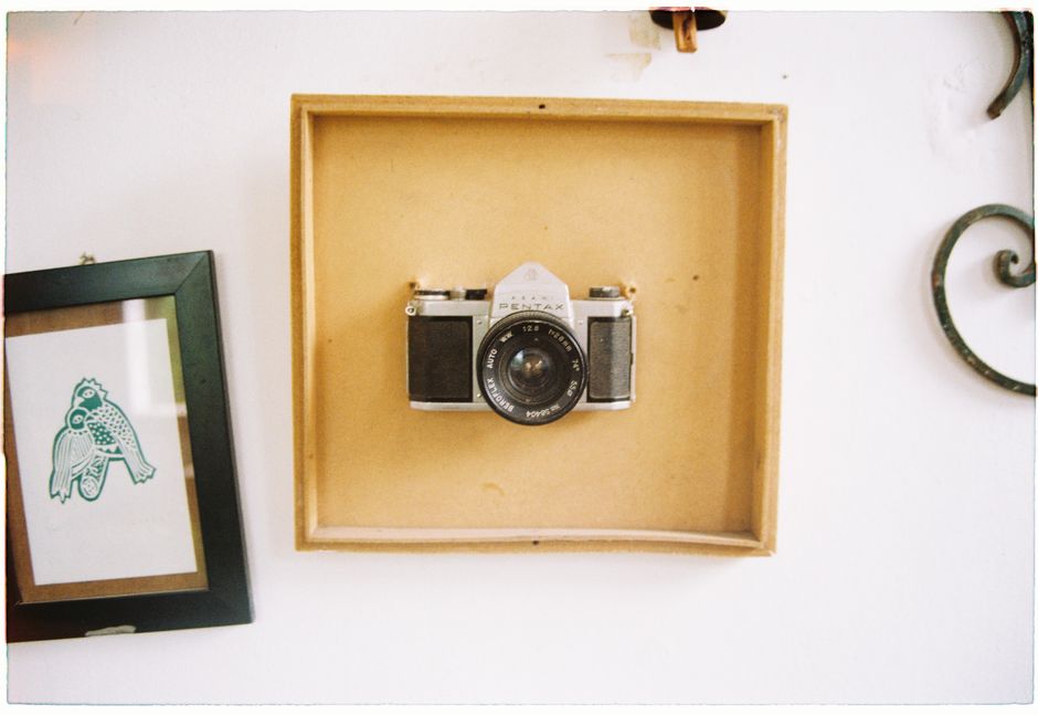 A vintage Pentax camera elegantly displayed in a shadow box on a wall for decor.