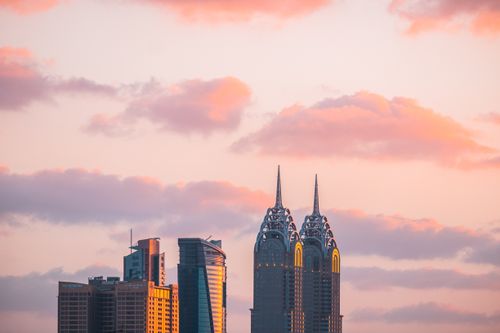 Free Stunning skyline photo at dawn with vibrant pink clouds over a city's iconic twin towers. Stock Photo