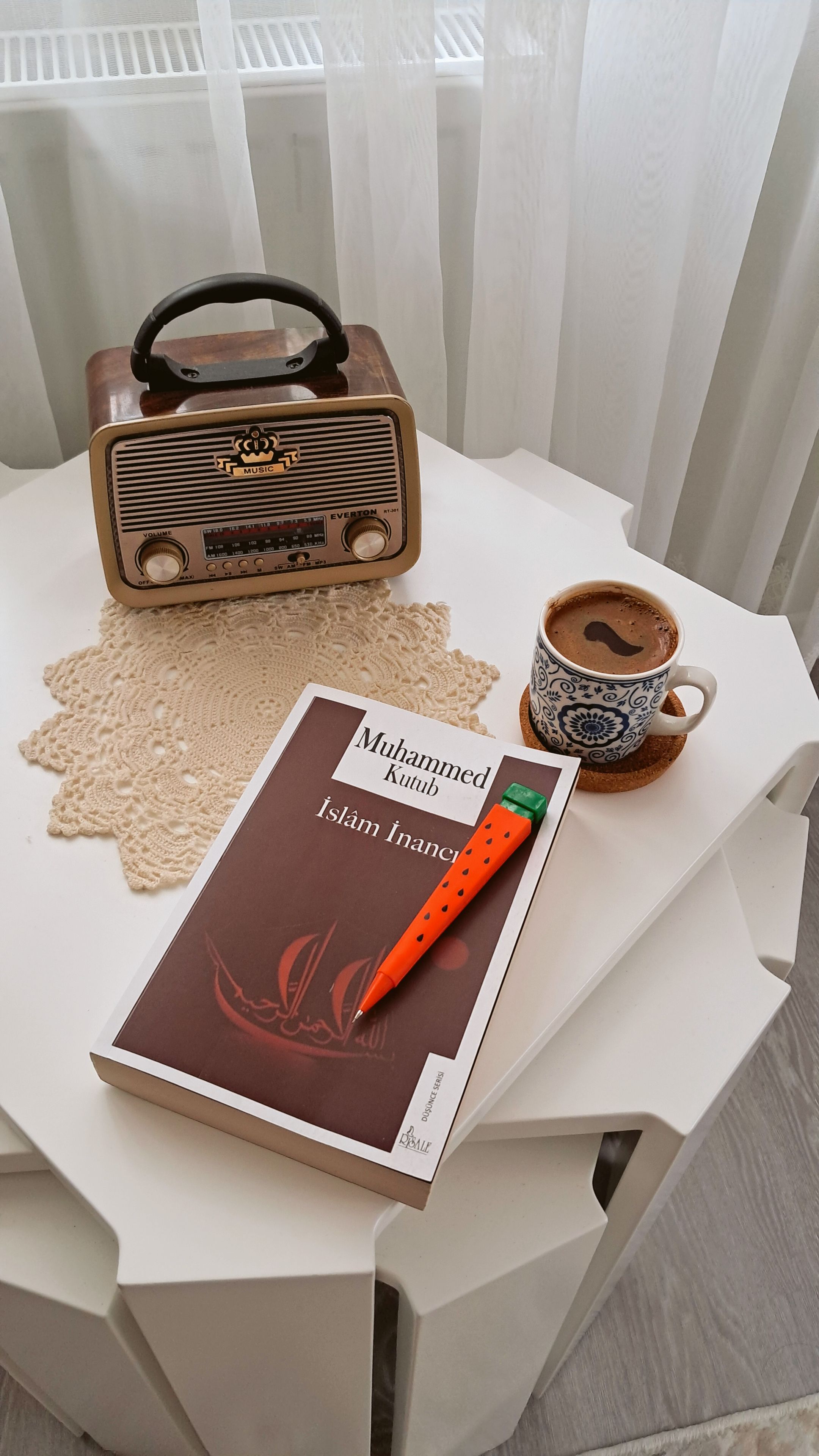 Vintage radio and book on a table create a cozy, nostalgic atmosphere.
