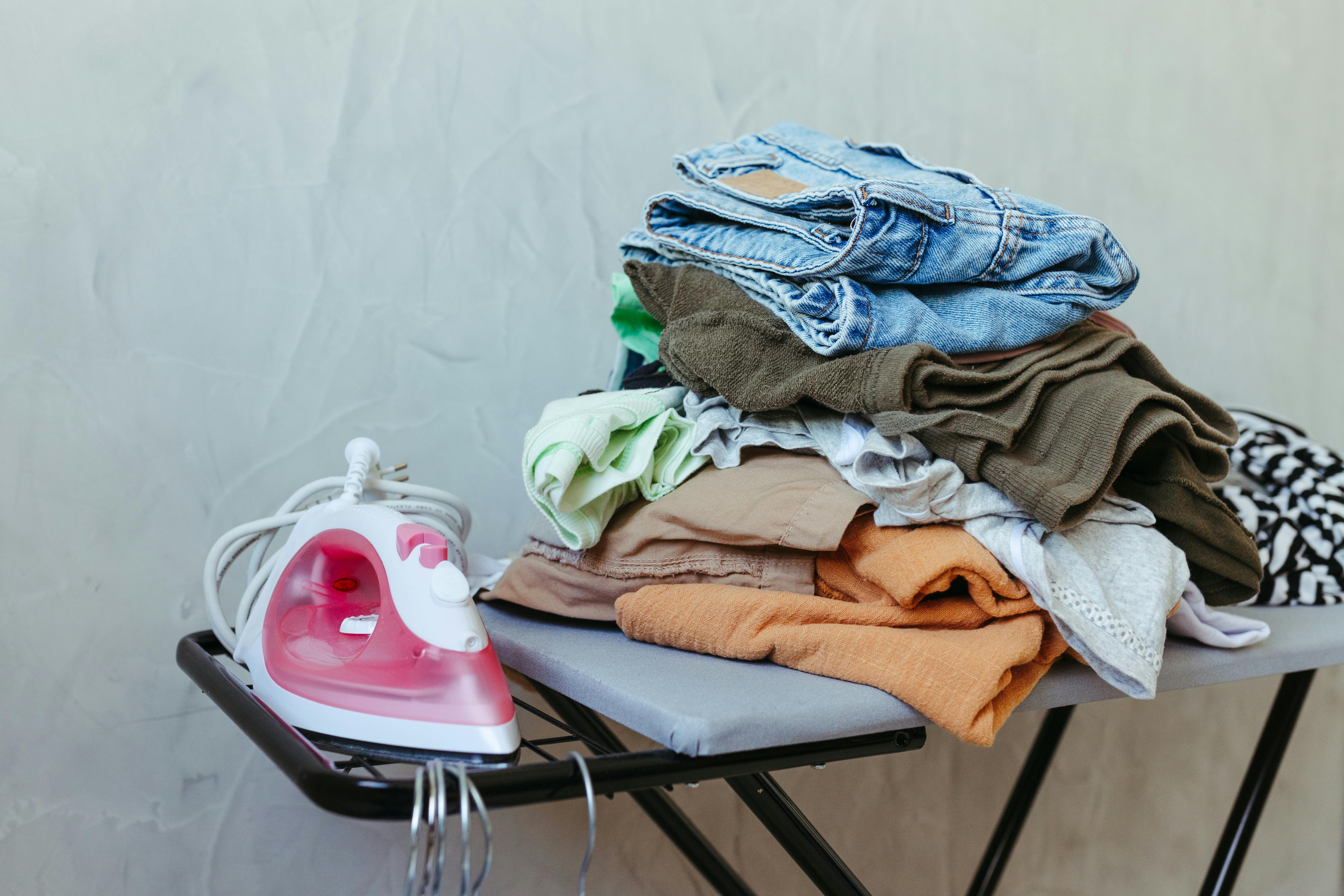 Free Freshly Ironed Clothes on Board with Steam Iron Stock Photo