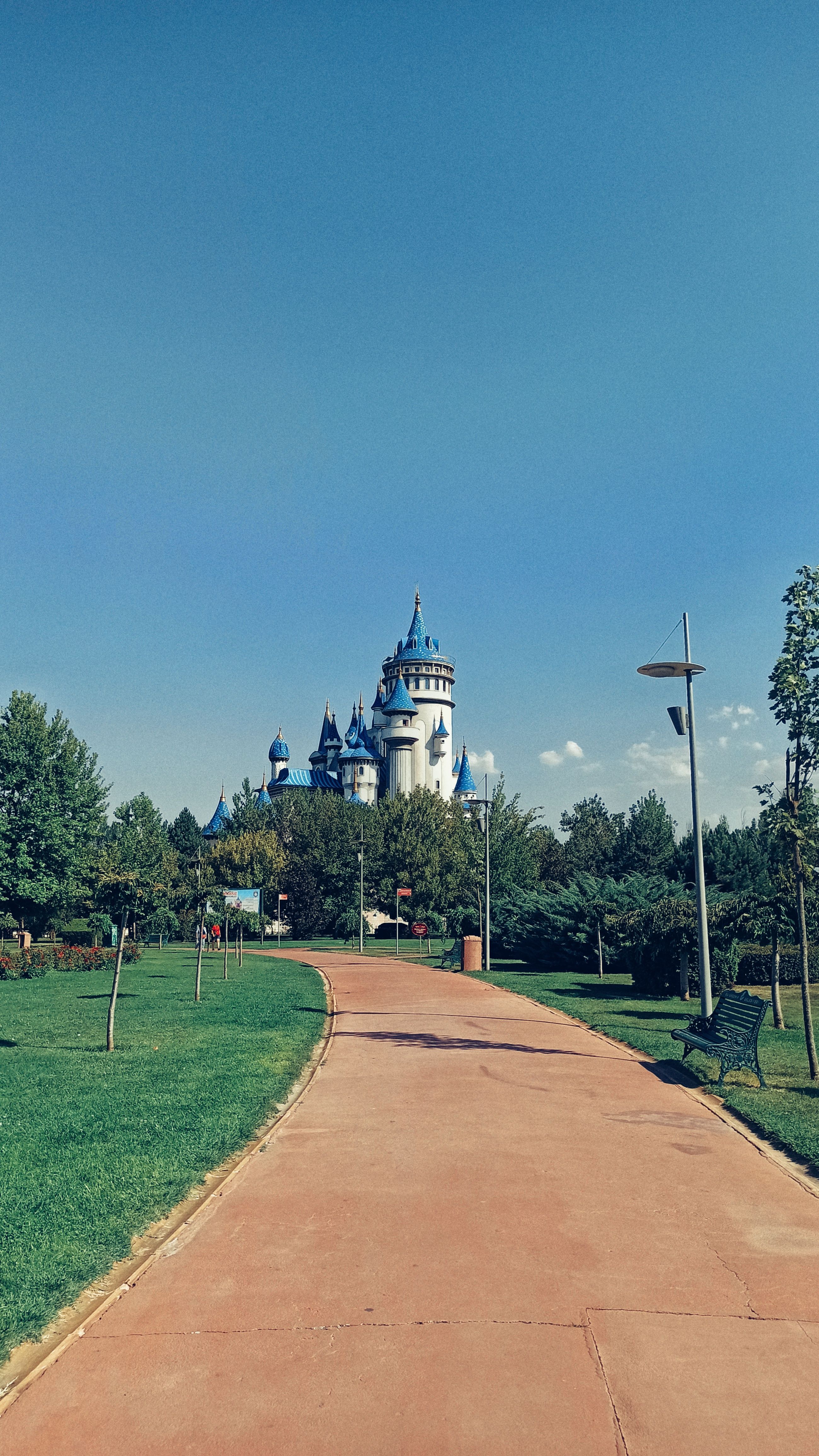 A beautiful castle surrounded by greenery, captured in a sunny park setting.