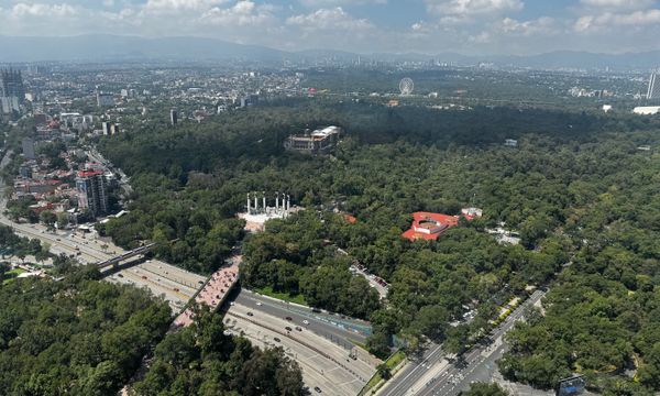 A stunning aerial view of Chapultepec Park with cityscape and mountains in the background.