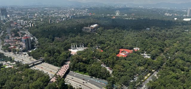 A stunning aerial view of Chapultepec Park with cityscape and mountains in the background.