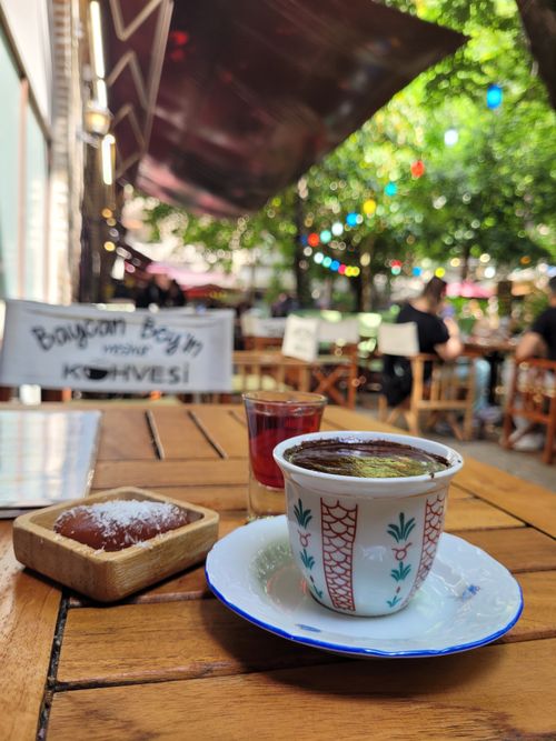 Free Turkish coffee and dessert at a vibrant outdoor café with colorful décor. Stock Photo