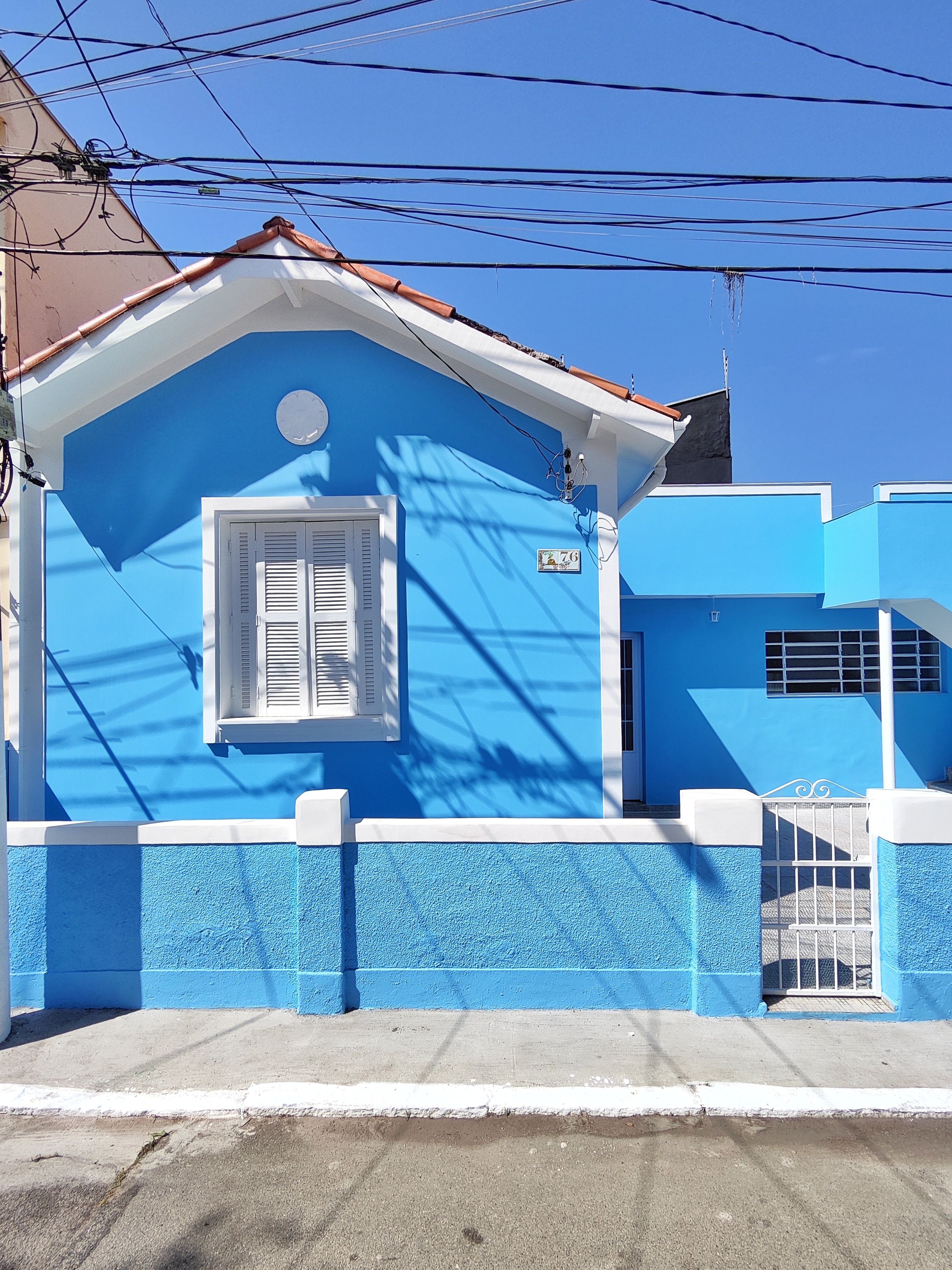 ฟรี บ้านสีฟ้าสดใสท่ามกลางทัศนียภาพเมืองอันสดใส คลังภาพถ่าย