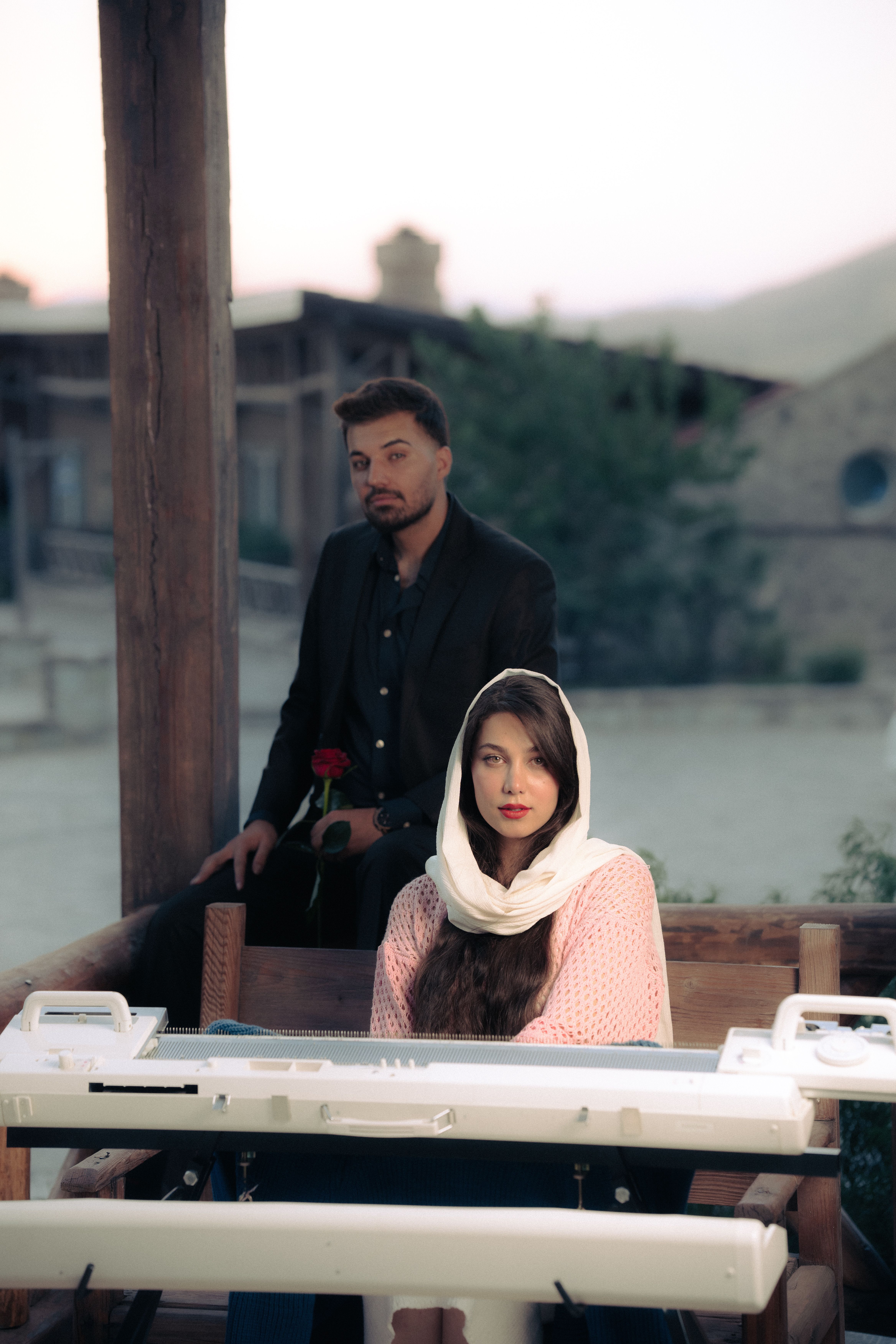 Elegant couple with piano experiencing a serene evening outdoors, romantic ambiance.