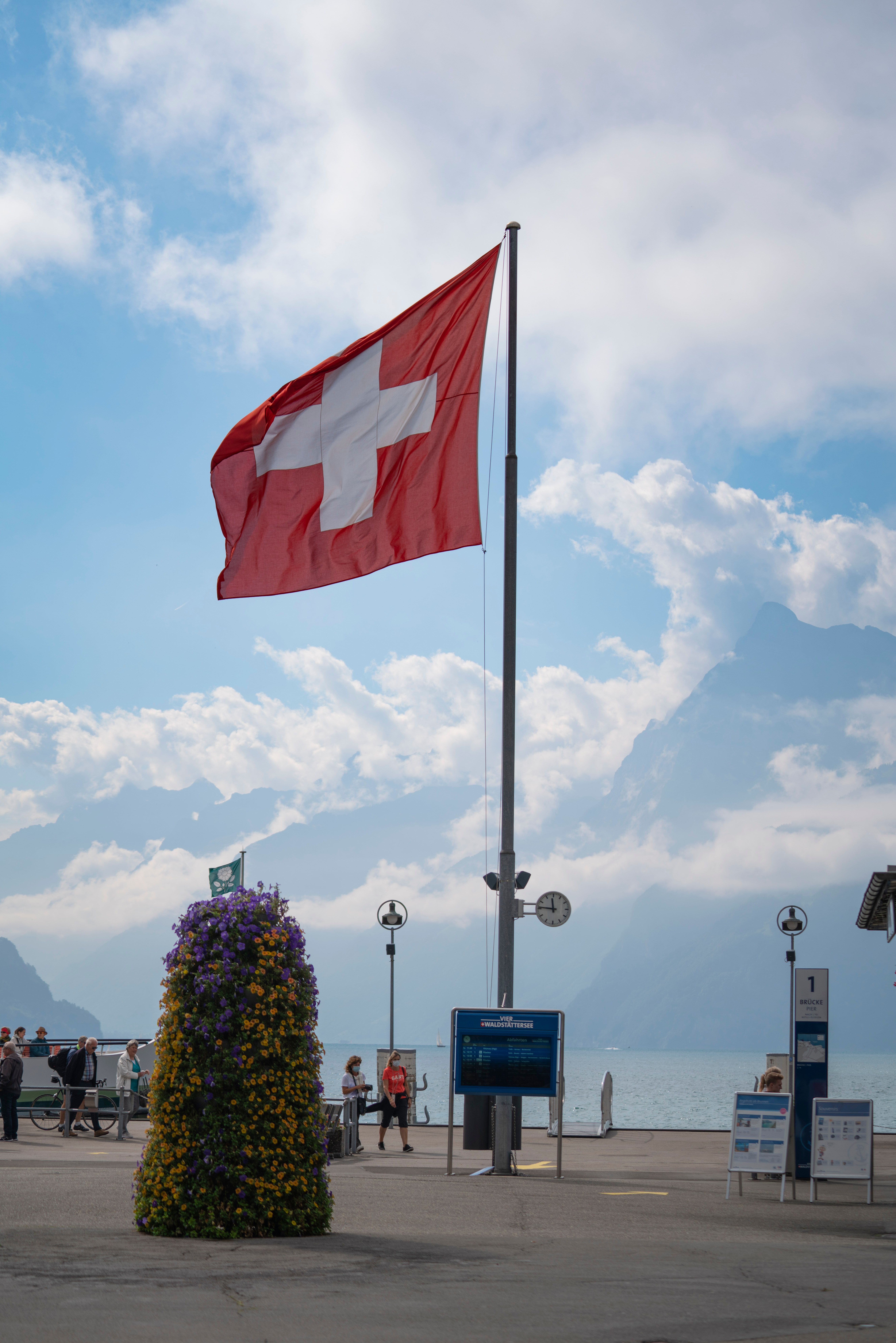 Swiss flag flying by Lake Geneva with the Alps in the background