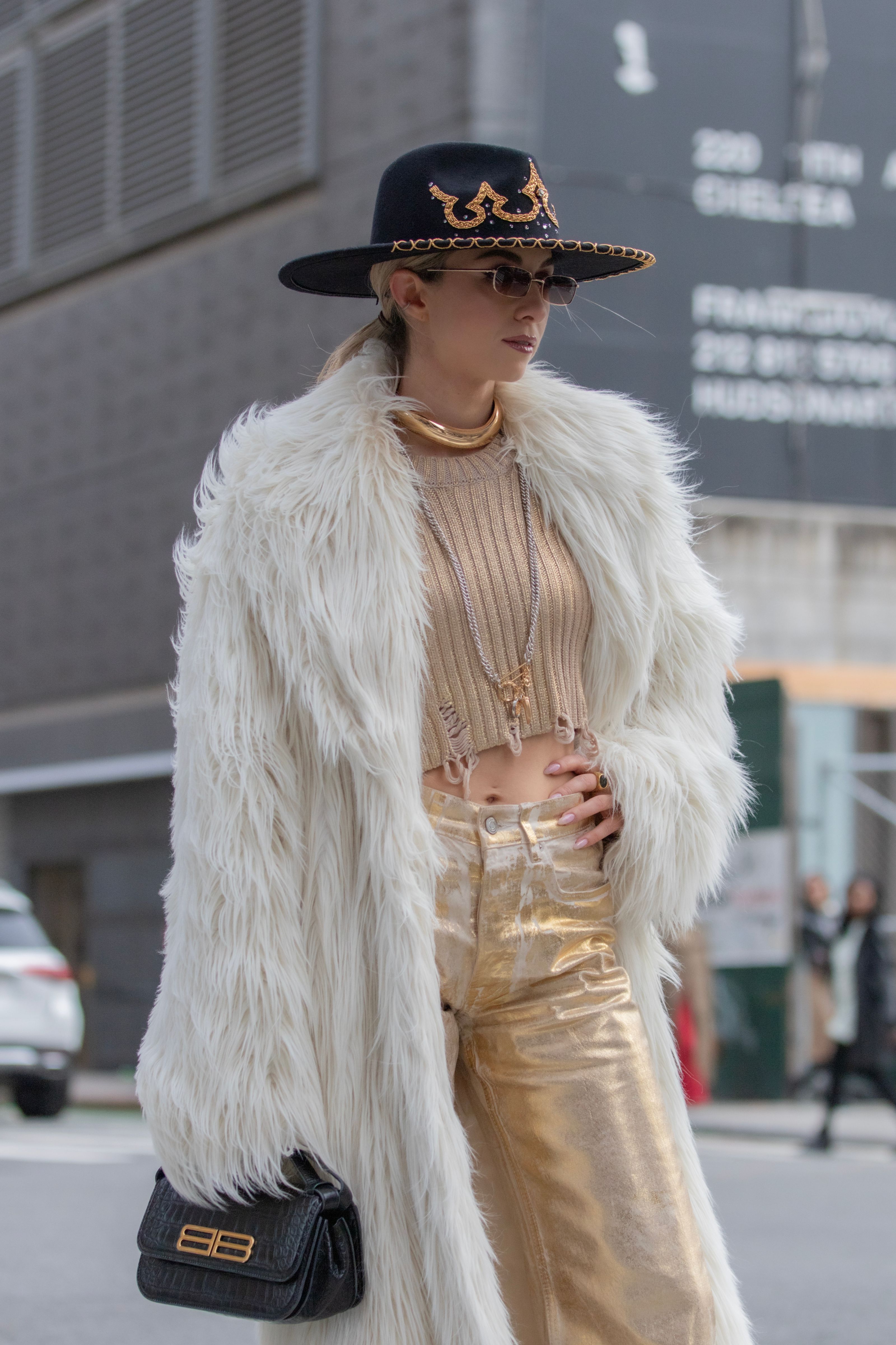 Mulher elegante em um sofisticado casaco de pele e chapéu, exalando o estilo de moda das ruas de NYC.