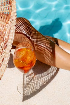 Sunlit poolside scene with Aperol spritz and relaxing vibes.