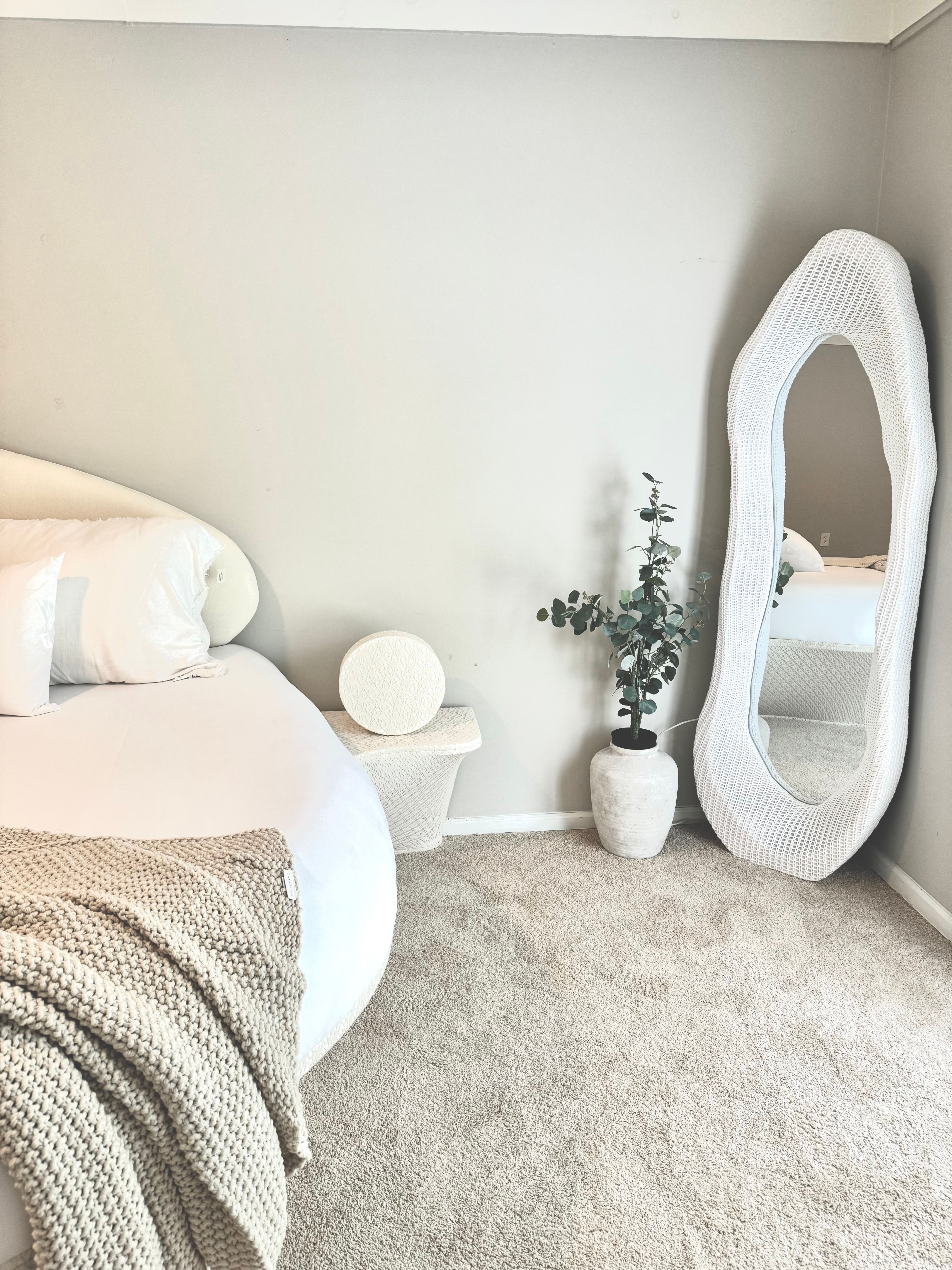 Modern minimalist bedroom with a large decorative mirror