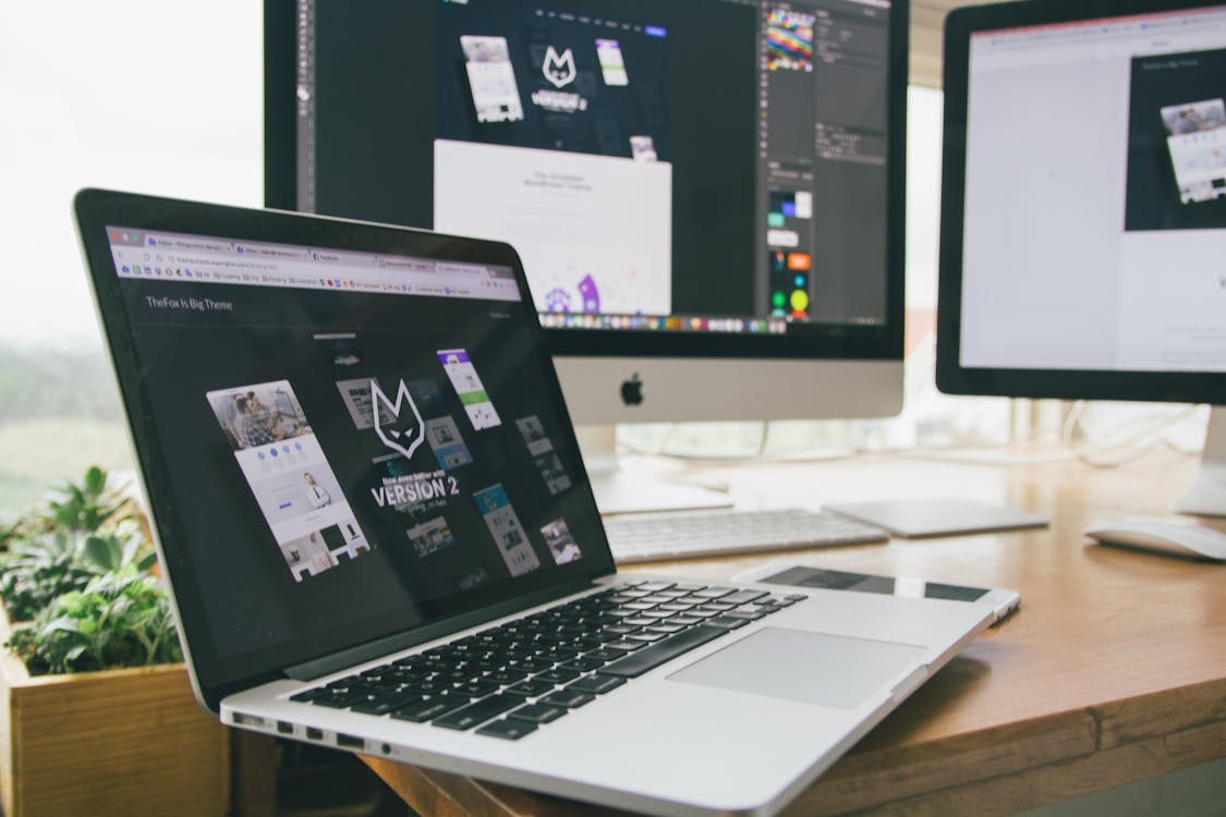 Free Macbook Pro Displaying Website Version 2 on Table Stock Photo