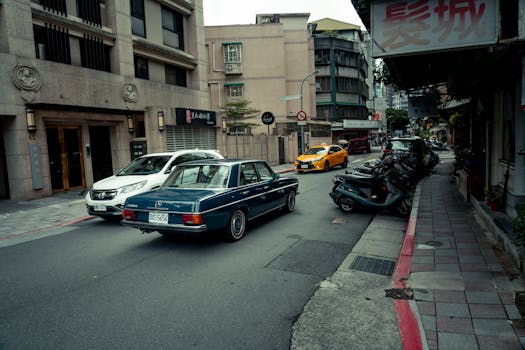 Vintage Mercedes Benz in bustling Taipei street scene with urban backdrop.