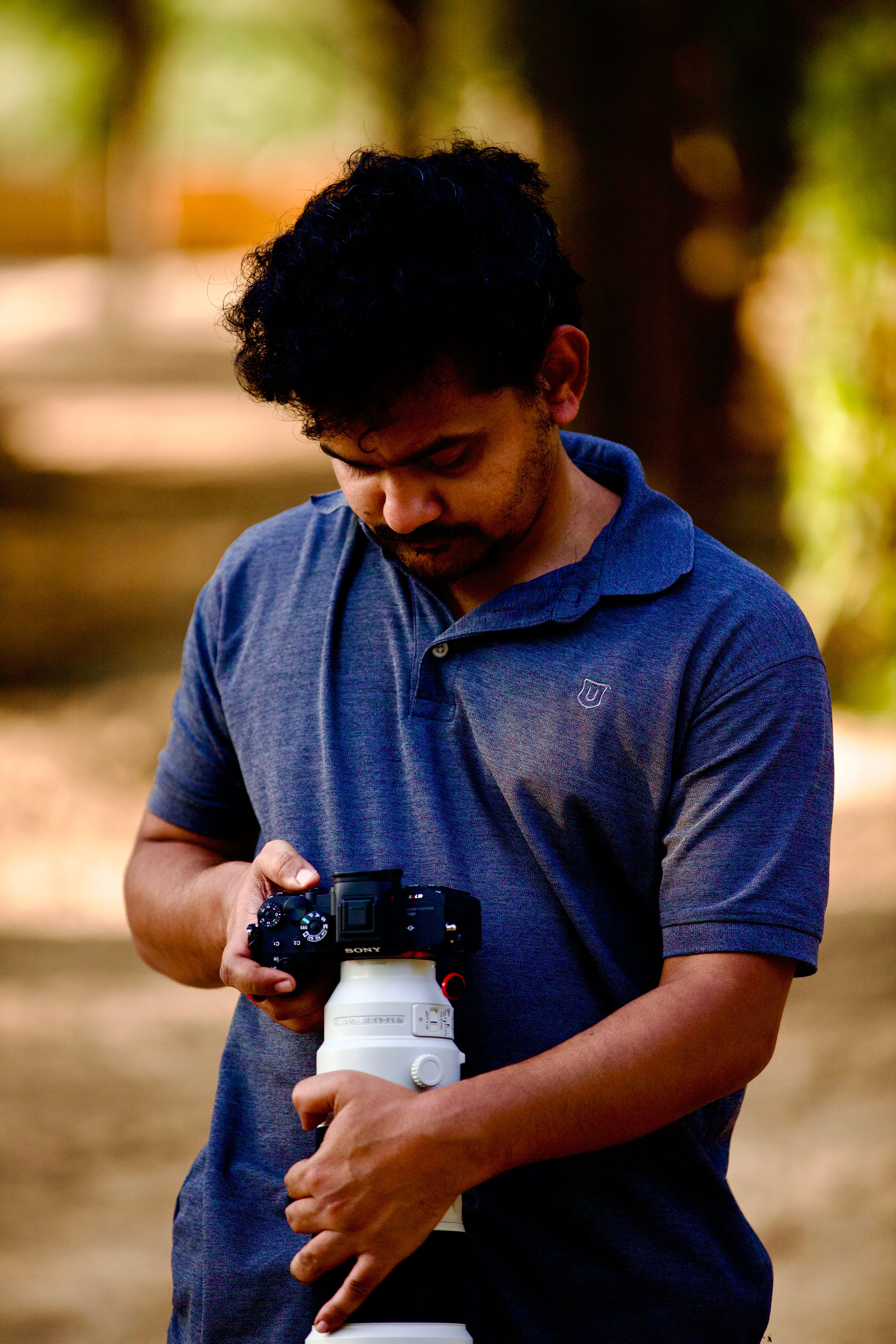 Photographer with DSLR camera focusing outdoors, perfect for professional photography themes.