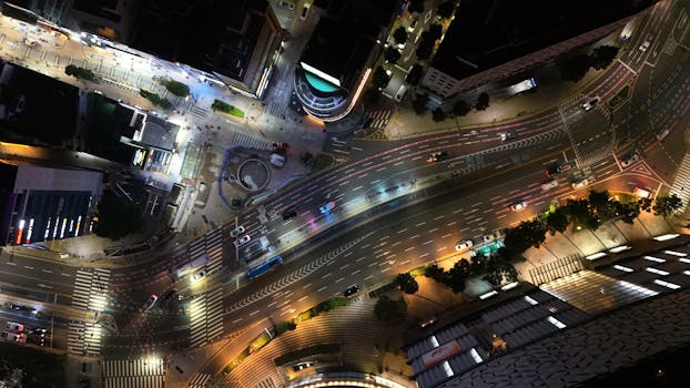 A vibrant aerial view of illuminated streets and traffic in Busan at night.