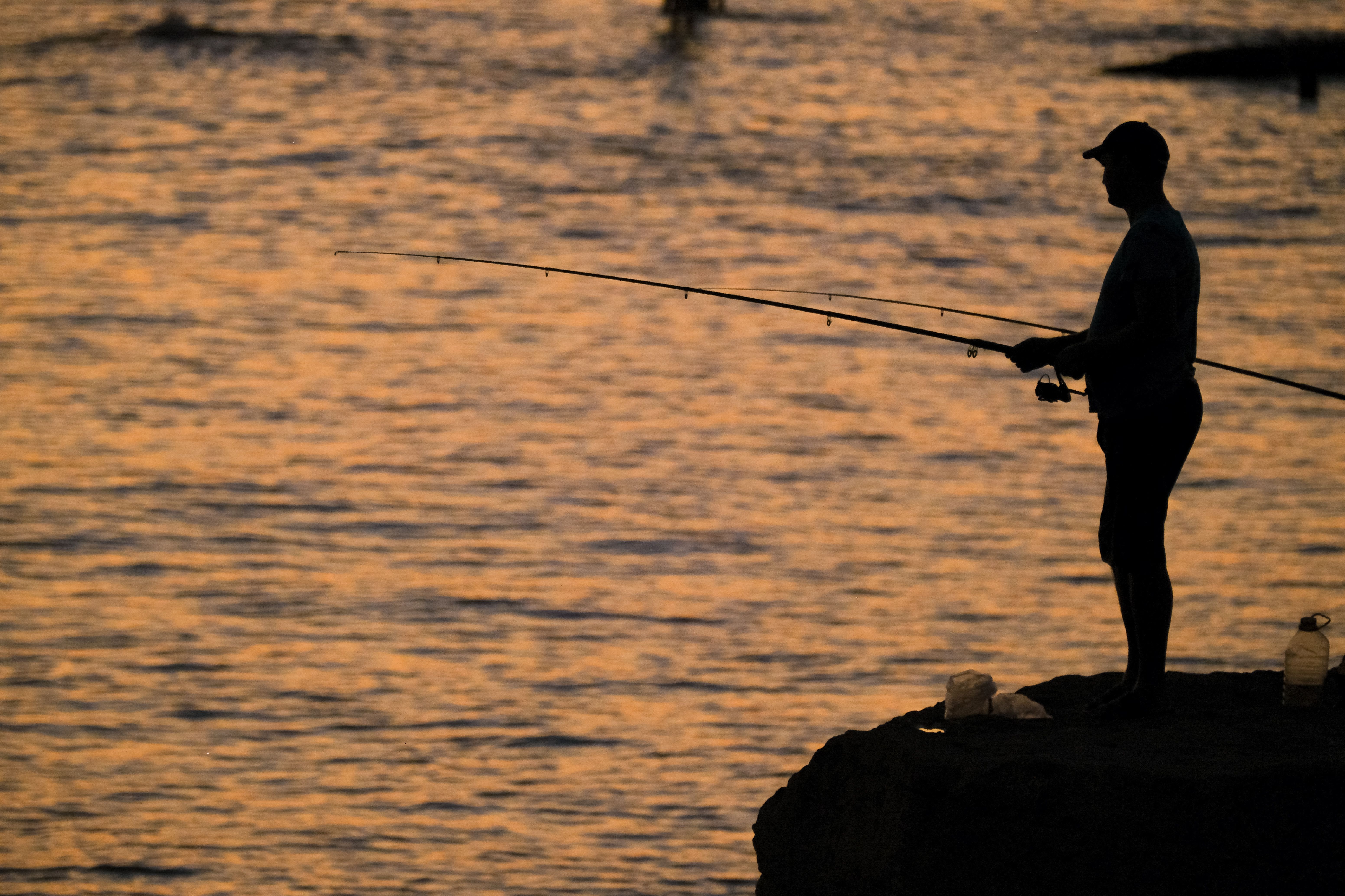 Silhouette of Fisherman at Sunset in Aktau · Free Stock Photo