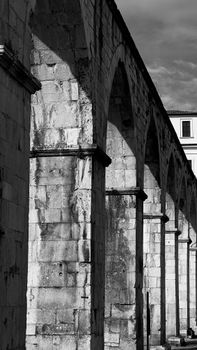 Monochrome view of ancient stone arches in Sulmona, showcasing classic Italian architecture.