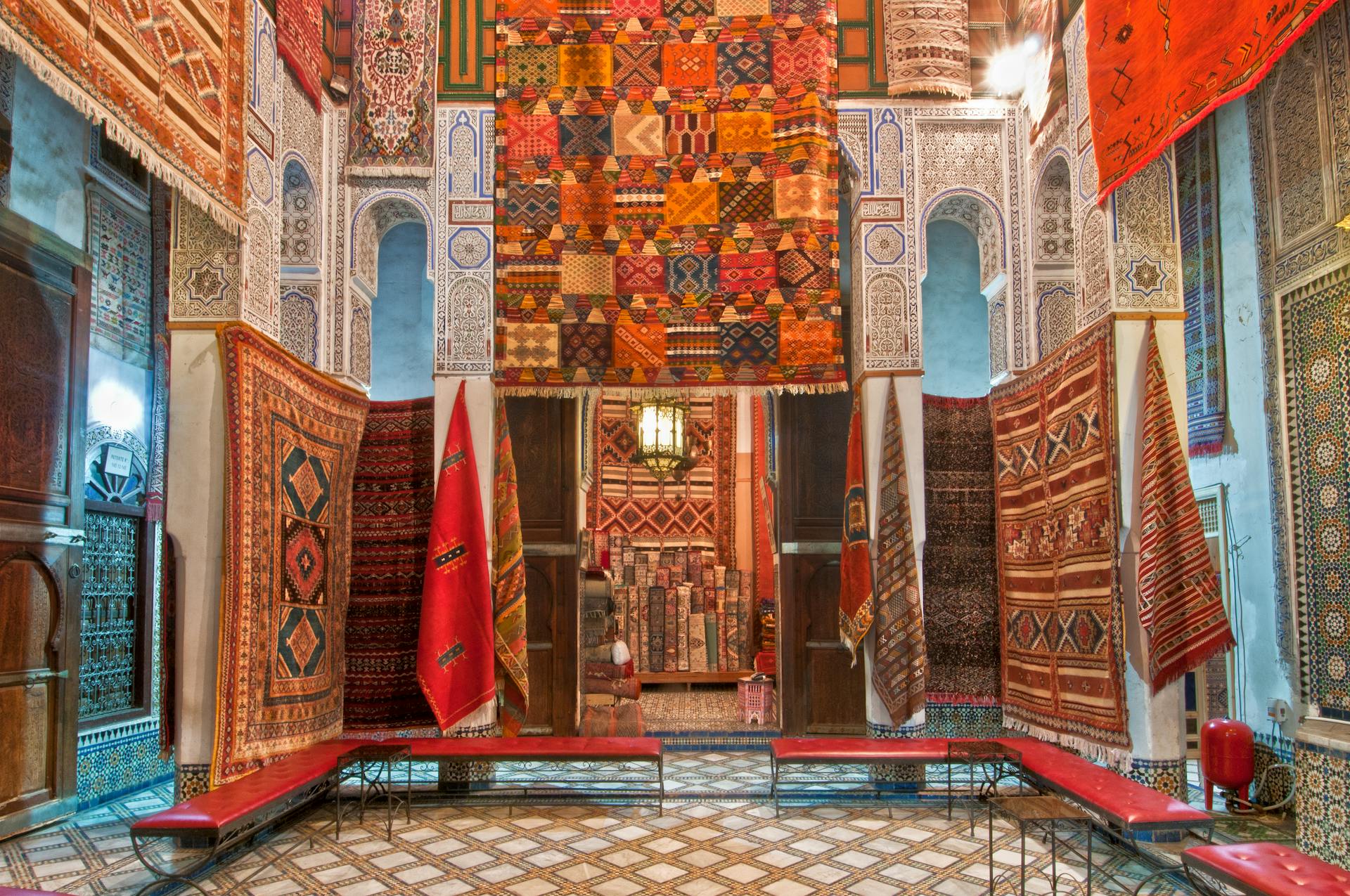 Colorful Moroccan rugs on display in a traditional interior in Fès, Morocco.