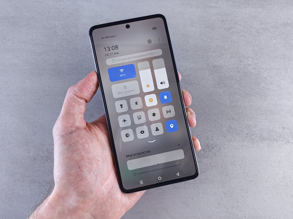 Mano che tiene uno smartphone con pannello delle impostazioni ben visibile