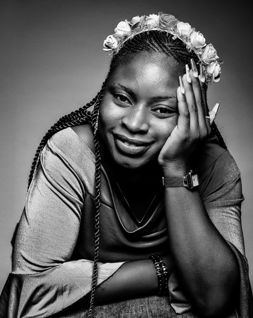 Free Artistic black and white portrait of a woman wearing a floral headband and smiling. Stock Photo