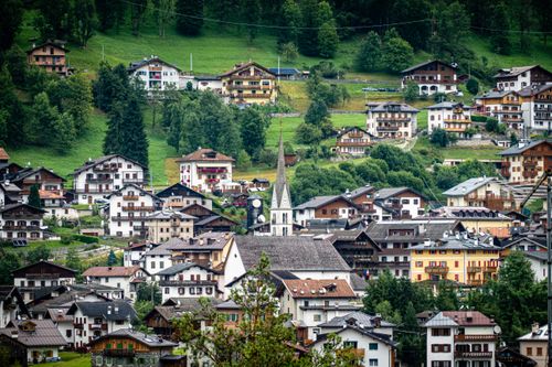 Free Picturesque alpine village nestled in lush greenery, showcasing quaint architecture and a beautiful church. Stock Photo
