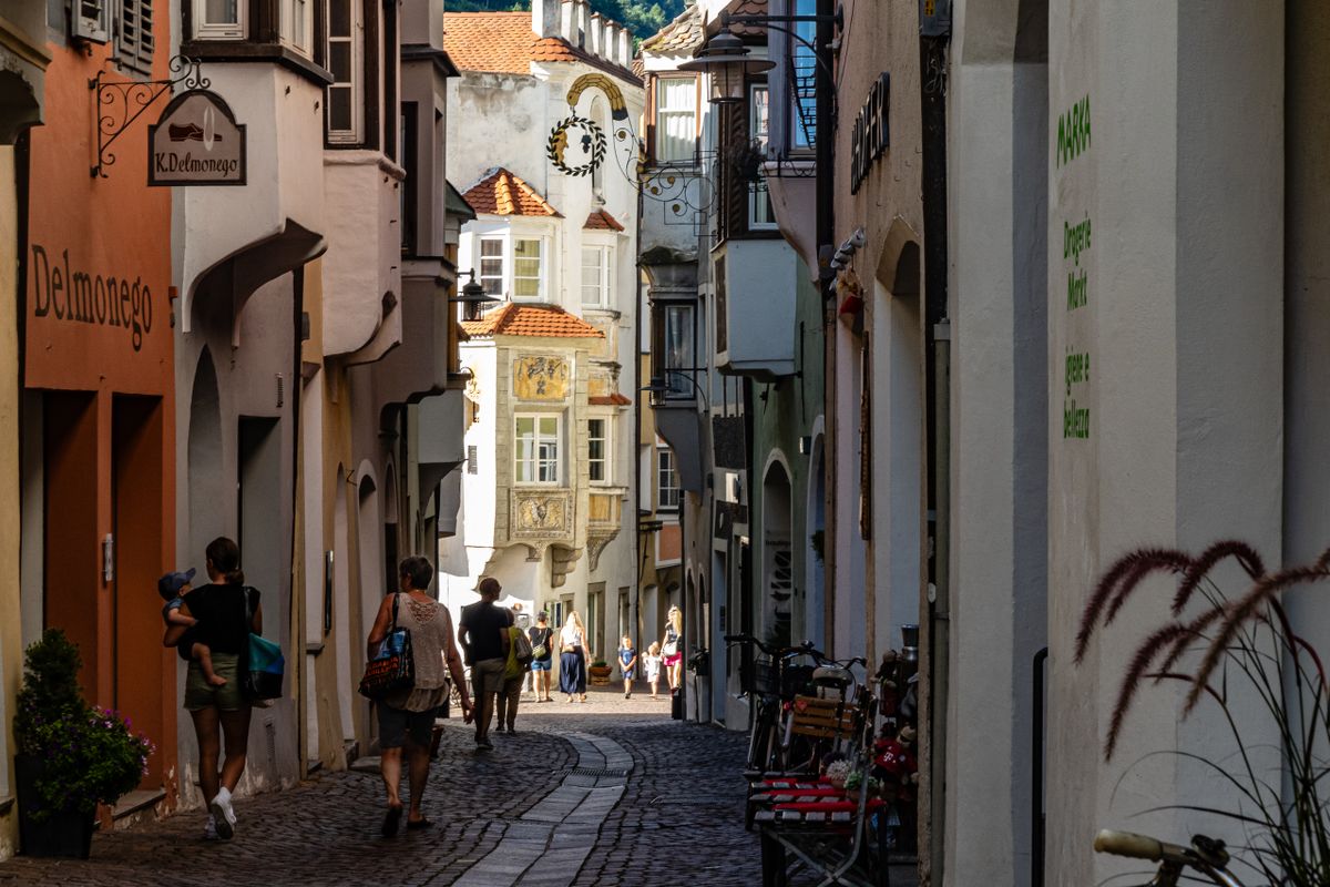 Narrow street in Bolzano with pedestrians and historic architecture