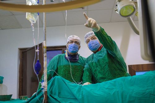 Free Two medical professionals operate in a Syrian hospital room, focused and equipped. Stock Photo