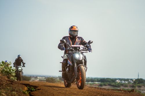 Free Riders on adventure motorcycles traversing a scenic dirt path, perfect for touring. Stock Photo