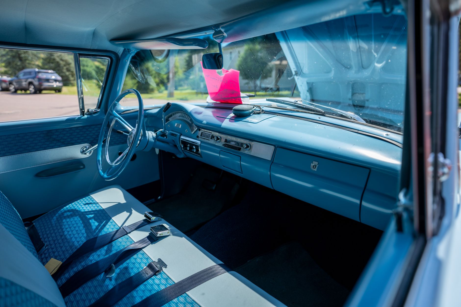 Classic blue car interior with steering wheel and dashboard, bright day in Nelson, WI.
