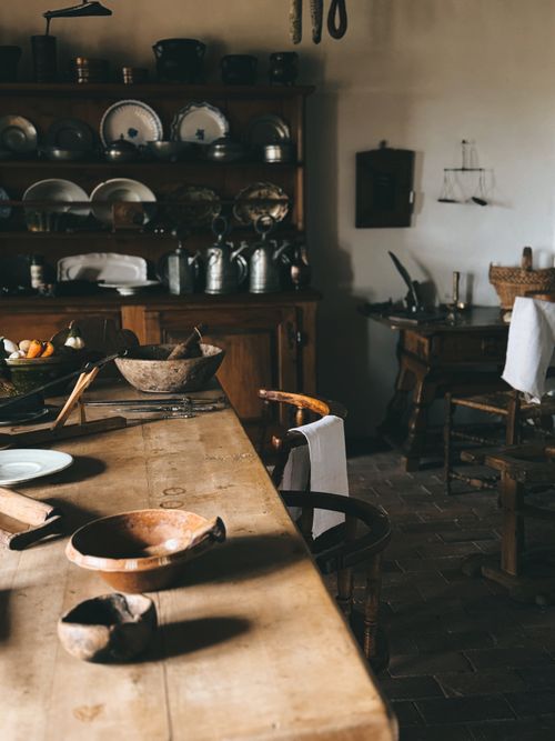 Free A cozy vintage kitchen featuring wooden utensils and shelves with plates and jars. Stock Photo