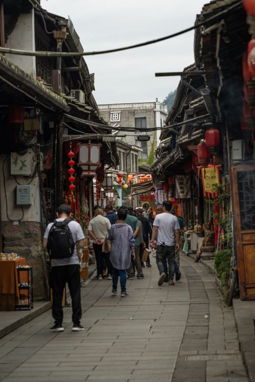 Free Busy traditional market street with people in an Asian town, showcasing vibrant lanterns. Stock Photo