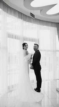 A timeless black and white photo of a couple on their wedding day in a sophisticated setting.