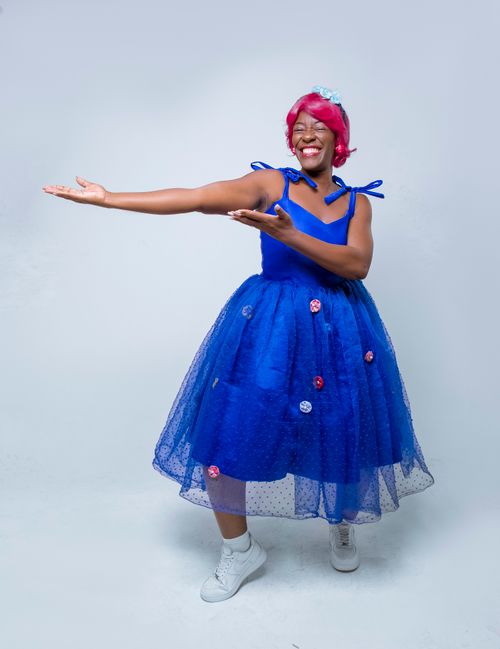 Free Vibrant image of a joyful woman in a blue dress with a playful pose. Stock Photo