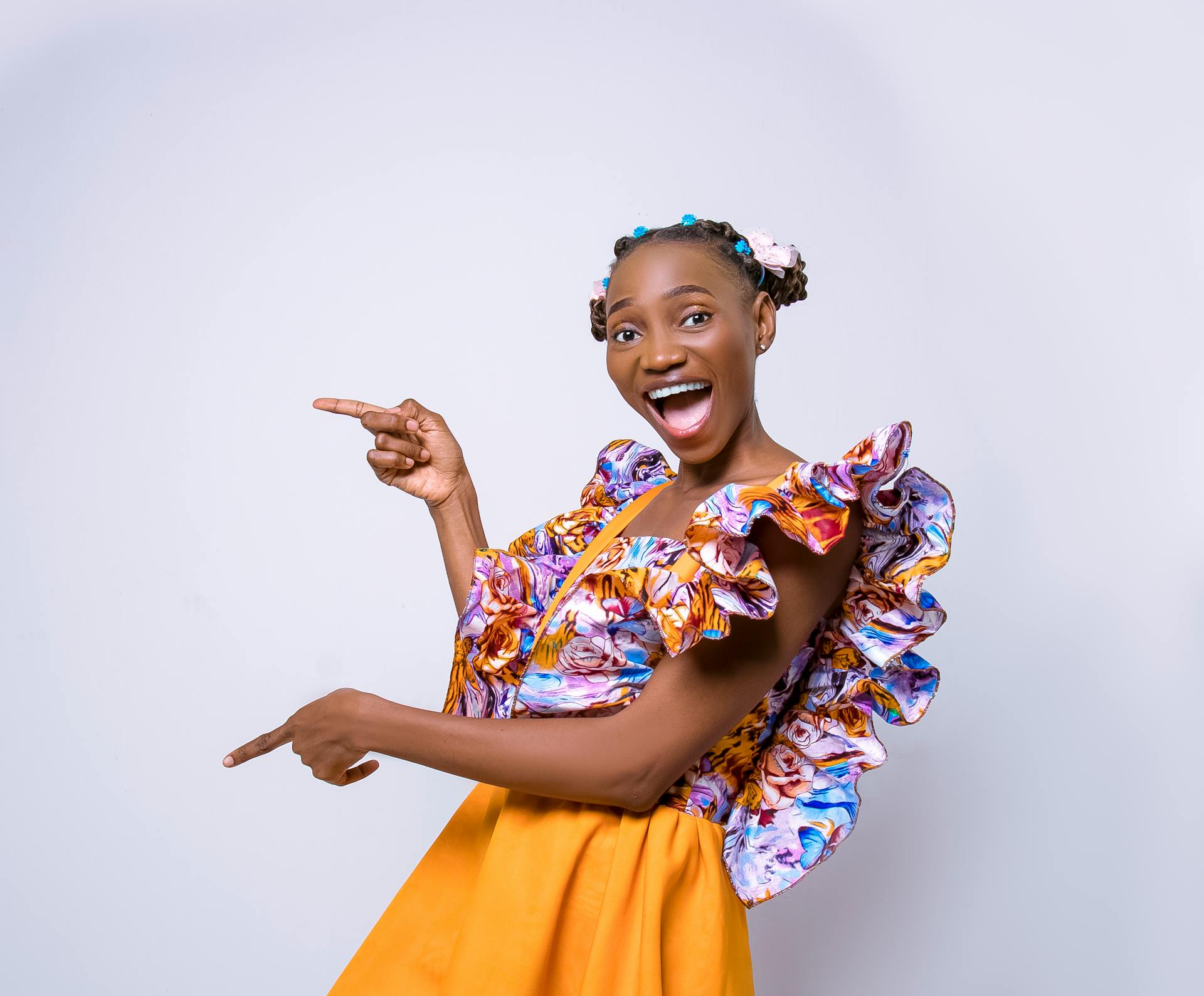 Vibrant Woman in Colorful Floral Dress Excitedly Pointing