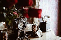 复古的豪华内饰中，大理石桌子上摆放着华丽的时钟和玫瑰