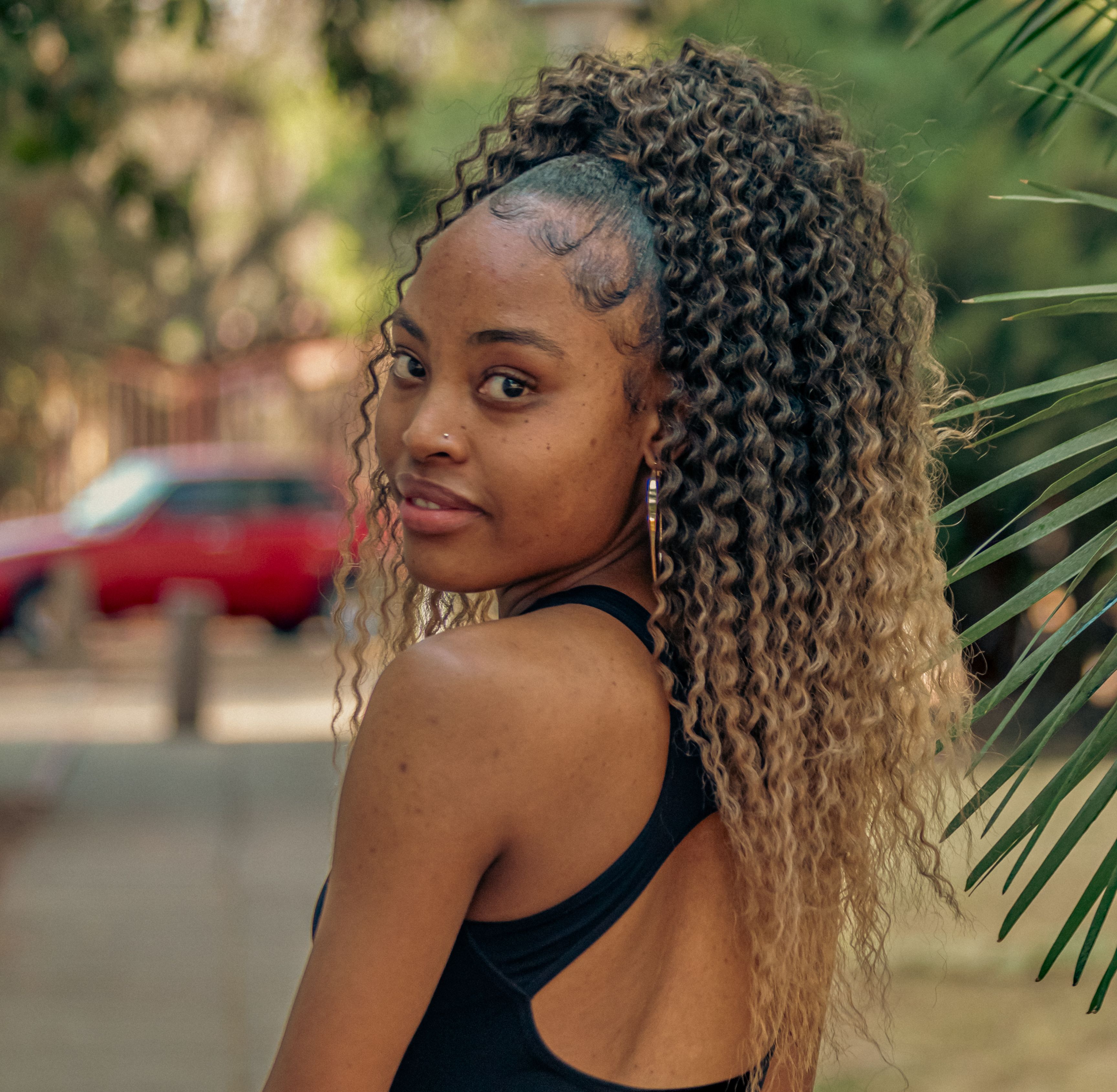Elegant young woman with curls outdoors, Pretoria, capturing youthful fashion and style.